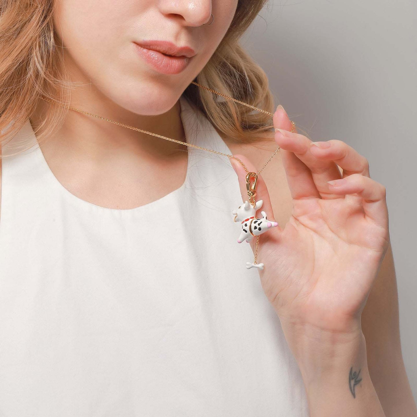 Close-up of a woman wearing the Dalmatian locket pendant necklace with enamel dog charm