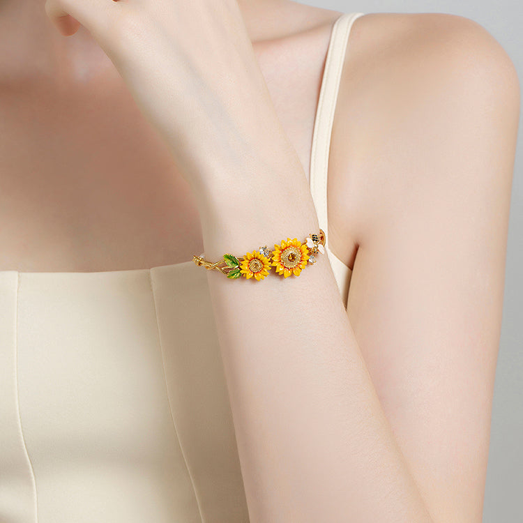 Woman wearing sunflower cuff bracelet with gold, yellow, and pearl accents on her wrist