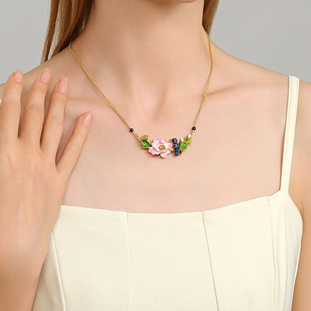 Elegant styled shot of the Kingfisher Lotus Necklace on model with hand near neckline