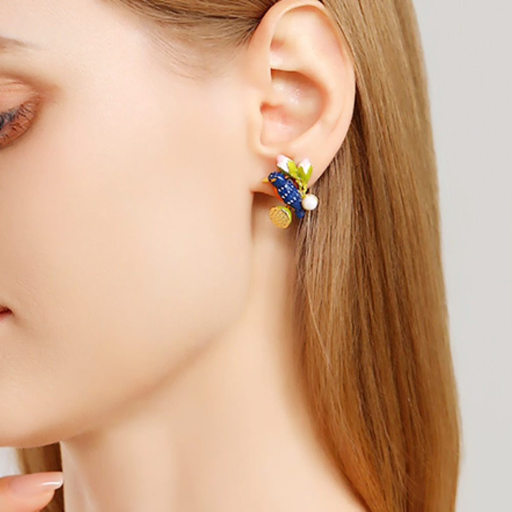 Close-up of a model wearing one Kingfisher Lotus Stud Earring on the left ear, showing the intricate enamel bird, lotus pod, and pearl.