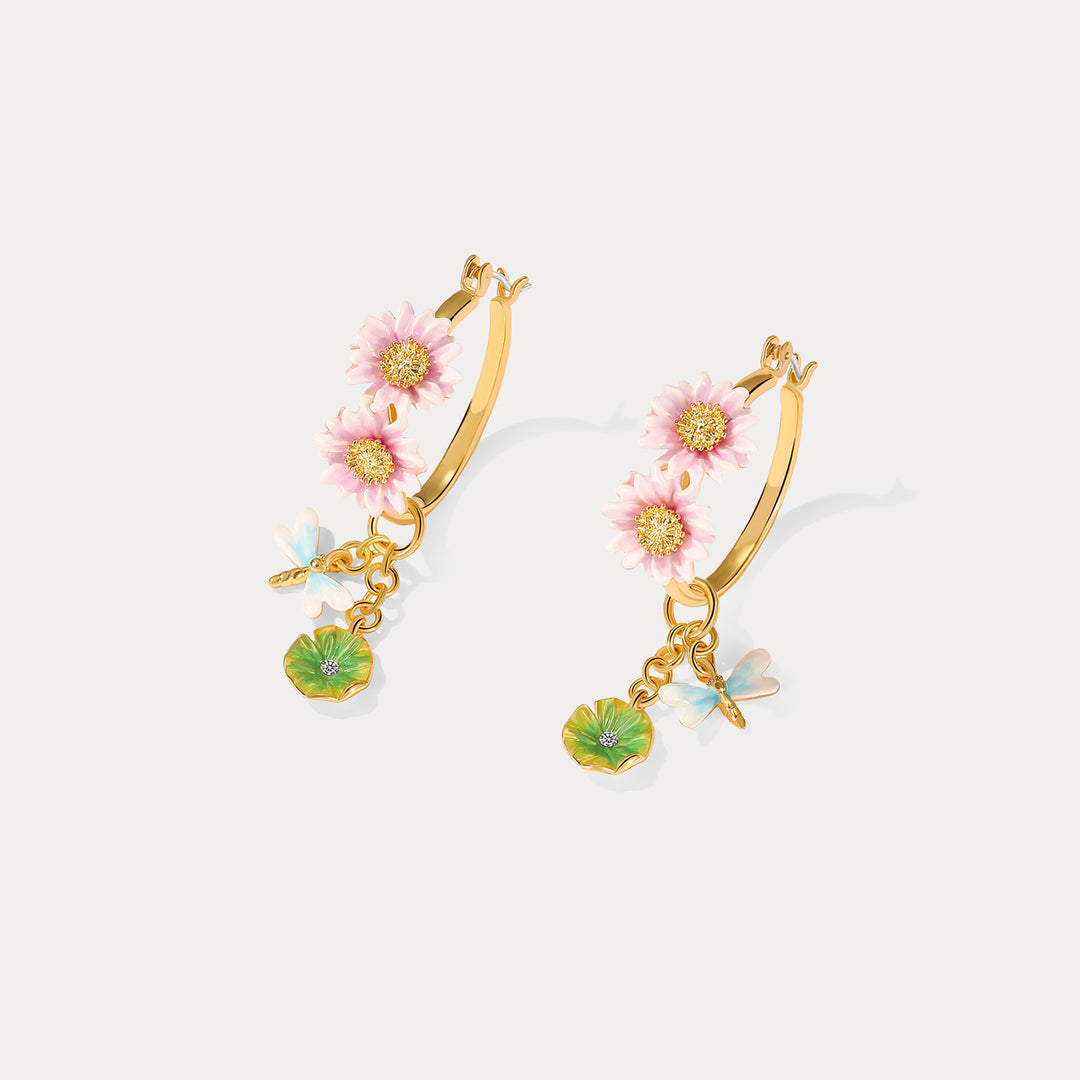 Overhead view of Lotus Dragonfly Hoop Earrings with detailed pink lotus blossoms and delicate green leaf charms.