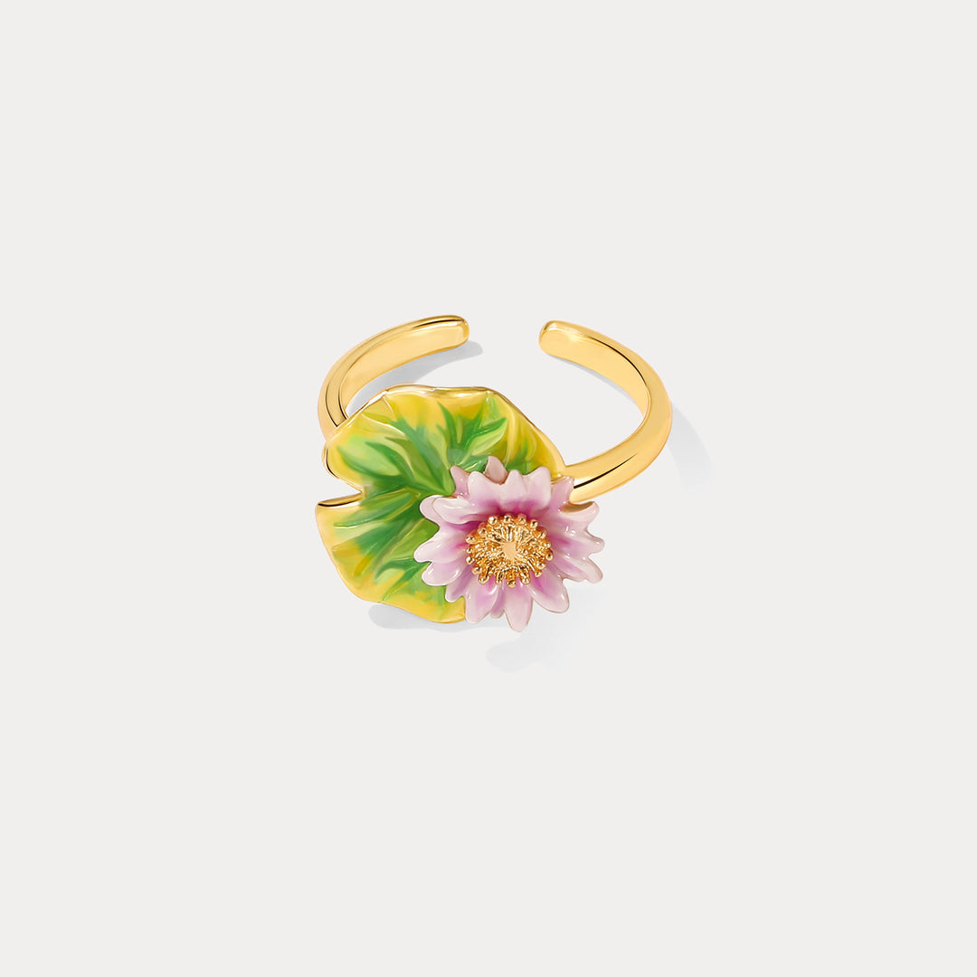 Angled view of lotus flower ring with gold band, pink flower and green enamel lotus leaf.