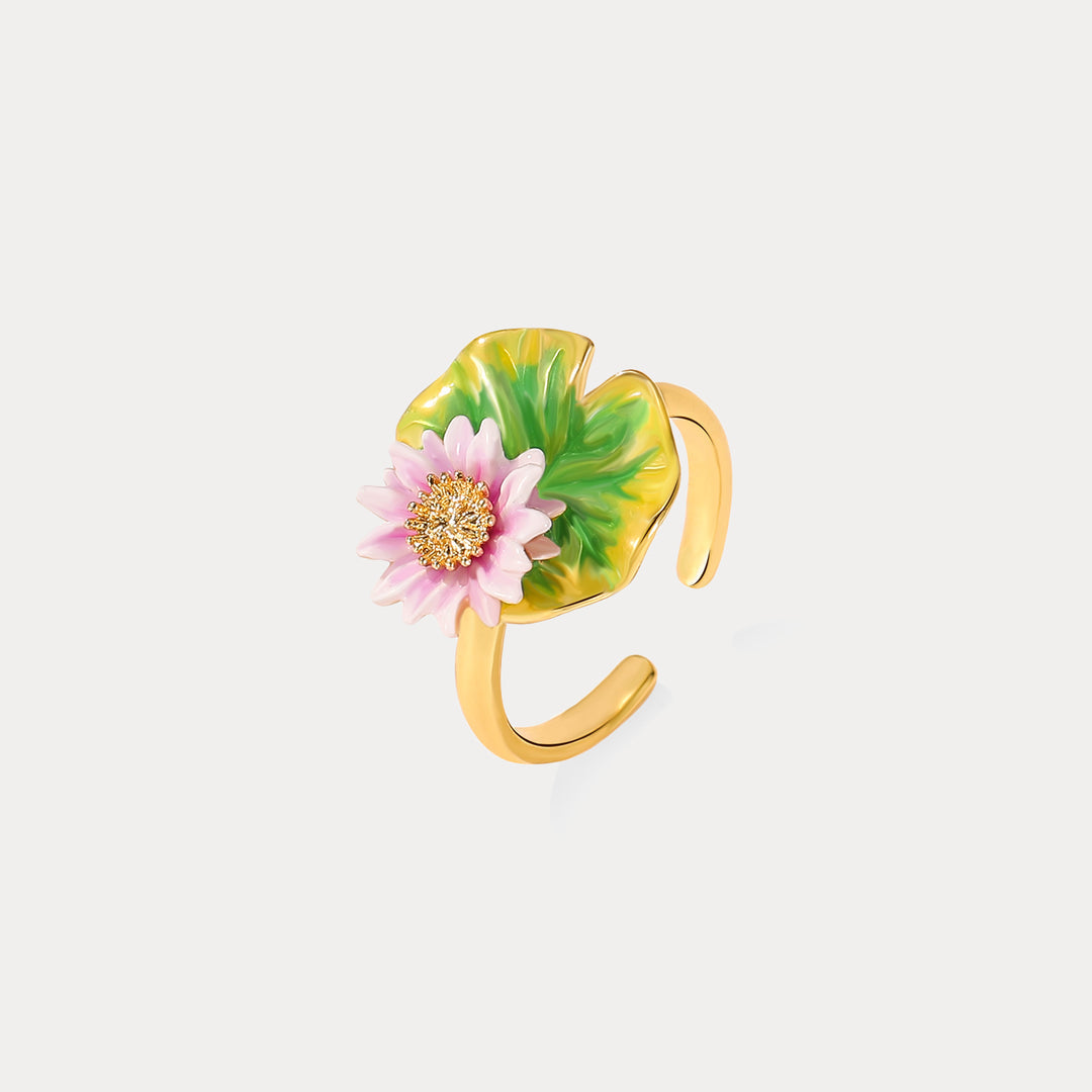 Lotus ring styled on a natural rock background, showing pink flower and green enamel lotus leaf.
