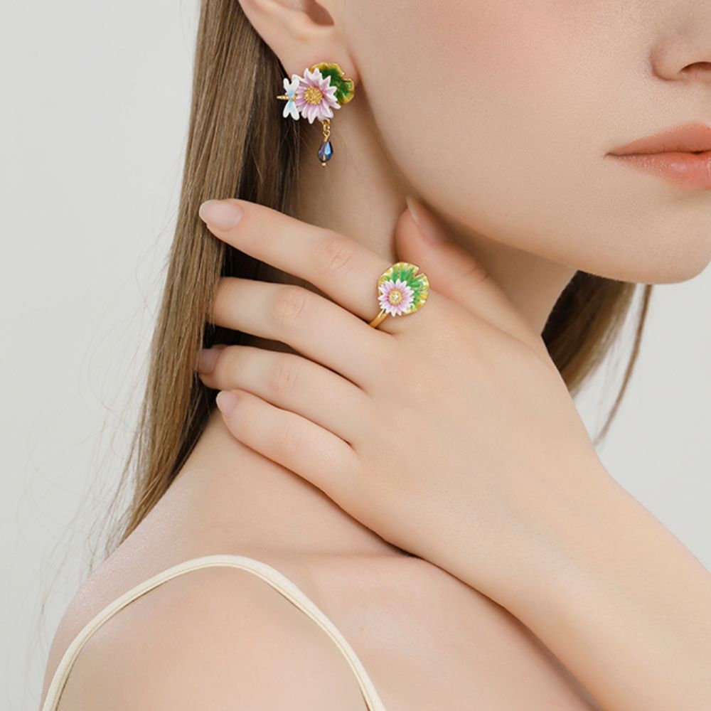 Close-up of lotus ring worn on hand, showing pink lotus flower and gold adjustable band.