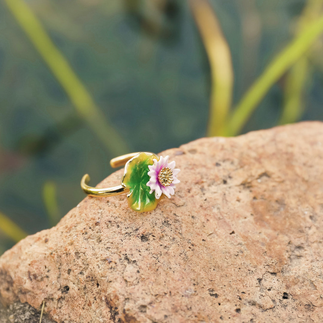 Model wearing lotus flower ring and matching enamel earrings, showing gold band and floral design.