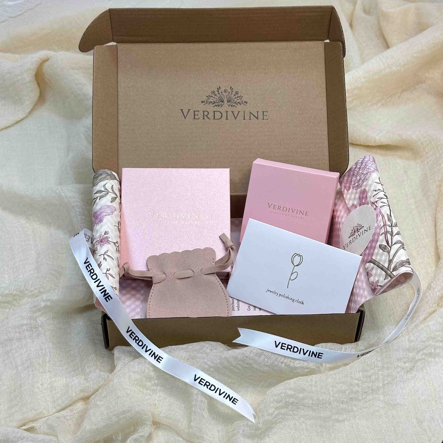 Lotus gift set packaging with Verdivine pink jewelry boxes, polishing cloth, and ribbon inside a brown box