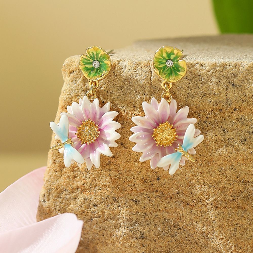 Close-up view of the Lotus Dragonfly Earrings with pink lotus flowers and delicate blue dragonflies, accented by green lily pad studs.