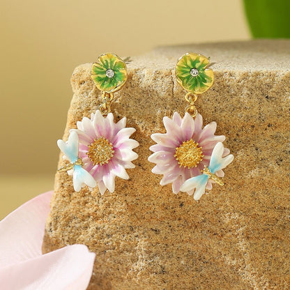 Close-up view of the Lotus Dragonfly Earrings with pink lotus flowers and delicate blue dragonflies, accented by green lily pad studs.