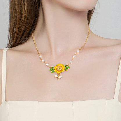 Zoomed-in chest view showing sunflower enamel pendant with bee charm and pearl links