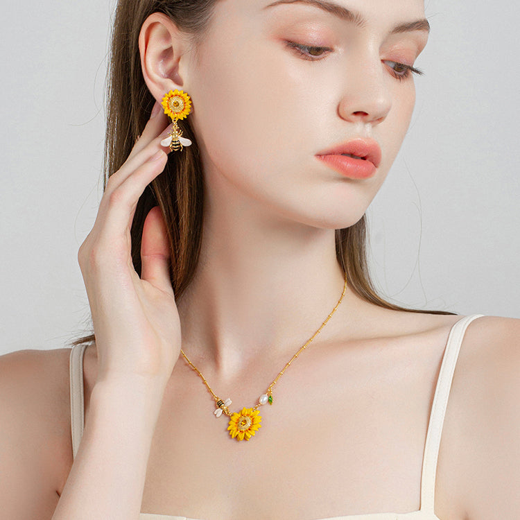 Detailed view of sunflower pendant necklace with enamel bee charm and pearl drop