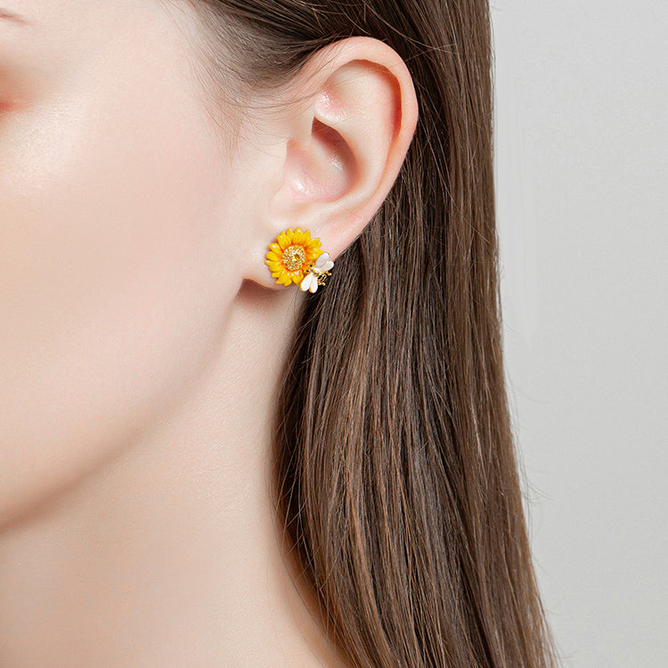 Model wearing Verdivine sunflower stud earrings with yellow petals and bee charm on earlobe