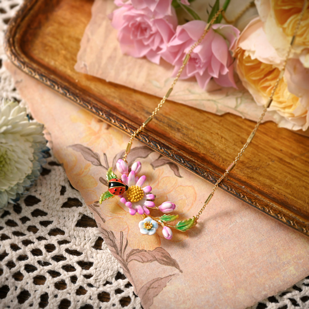 Daisy Ladybug Necklace styled on vintage paper and roses
