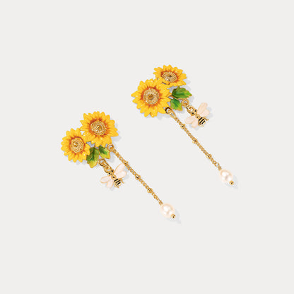 Pair of Verdivine sunflower earrings displayed on a white background, showcasing gold chains and bee 
