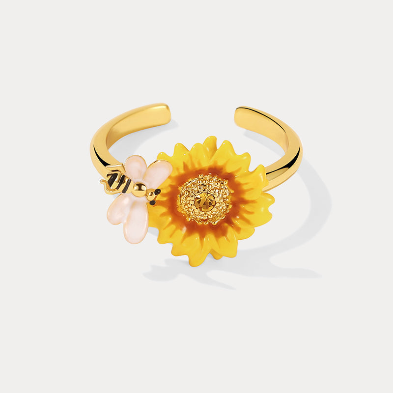 Detailed front shot of sunflower ring with gold center and white-winged bee charm on white background