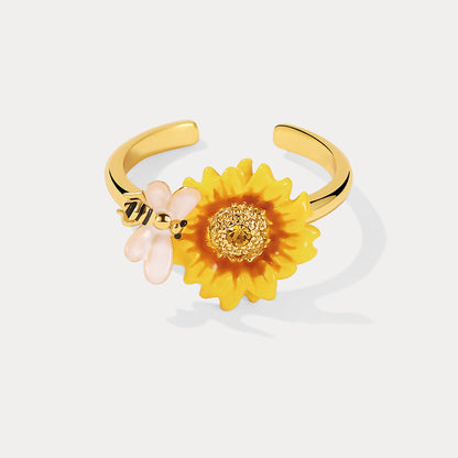 Detailed front shot of sunflower ring with gold center and white-winged bee charm on white background