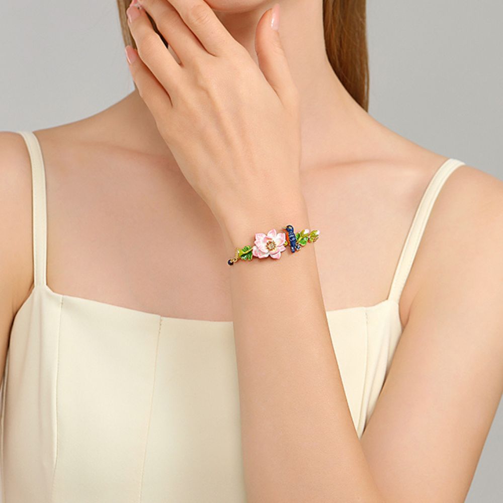 Model's arm positioned forward to show the bracelet’s central floral and bird motifs, making the design the main focal point.