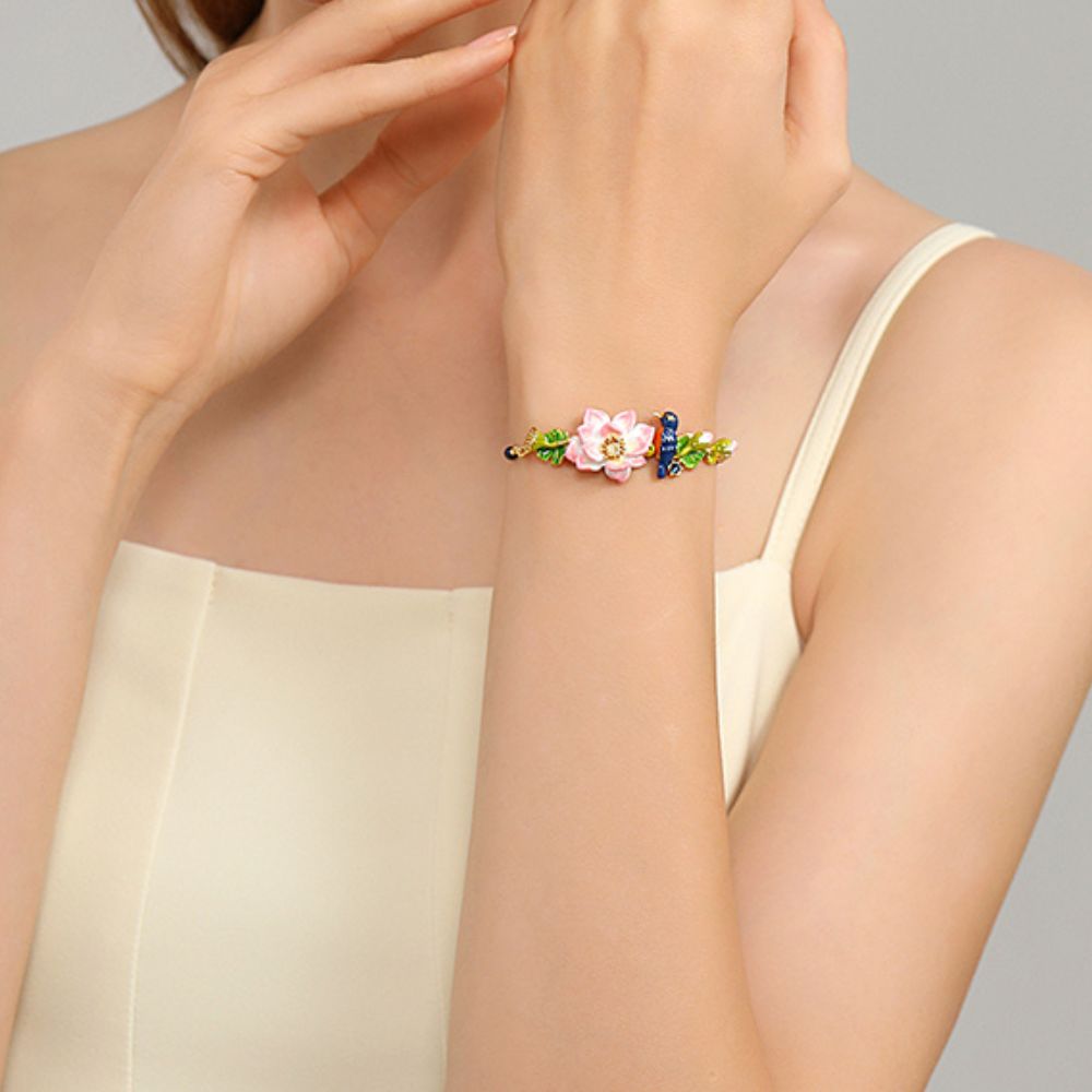 Close-up view of the bracelet focusing on the lotus flower and kingfisher bird, with gold chain and colorful enamel leaf detailing.