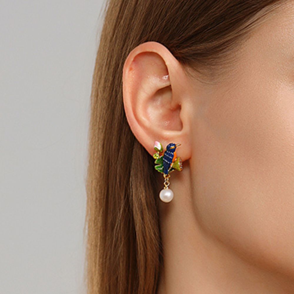 Model’s left ear adorned with a Kingfisher Lotus Earring, highlighting the intricate blue bird, green leaves, and white pearl drop.