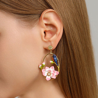 Gold hoop earrings featuring pink enamel lotus flowers and kingfisher bird design