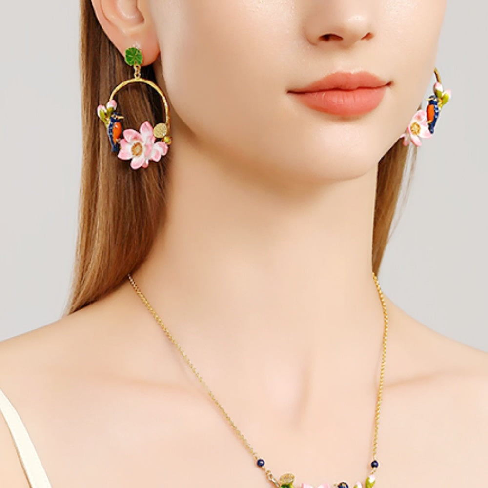 Close-up of a model wearing one Kingfisher Lotus Hoop Earring on the right ear, featuring a pink lotus and enamel kingfisher bird.