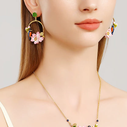 Close-up of a model wearing one Kingfisher Lotus Hoop Earring on the right ear, featuring a pink lotus and enamel kingfisher bird.