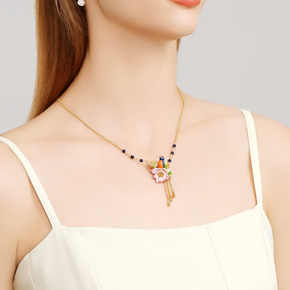 Detailed view of the Kingfisher Lotus Necklace featuring a pink lotus flower and a blue enamel bird pendant.