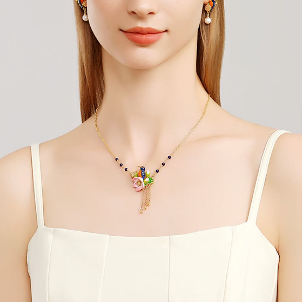 Straight-on view of the Kingfisher Lotus Necklace showing the full enamel flower and blue bird pendant.