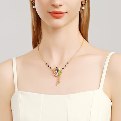 Straight-on view of the Kingfisher Lotus Necklace showing the full enamel flower and blue bird pendant.