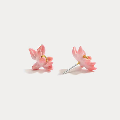 Pair of pink lotus-shaped enamel stud earrings displayed on a white background, showing front and angled views.