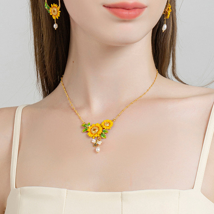 Close-up of a model wearing Verdivine’s sunflower statement necklace with bee and pearl detail