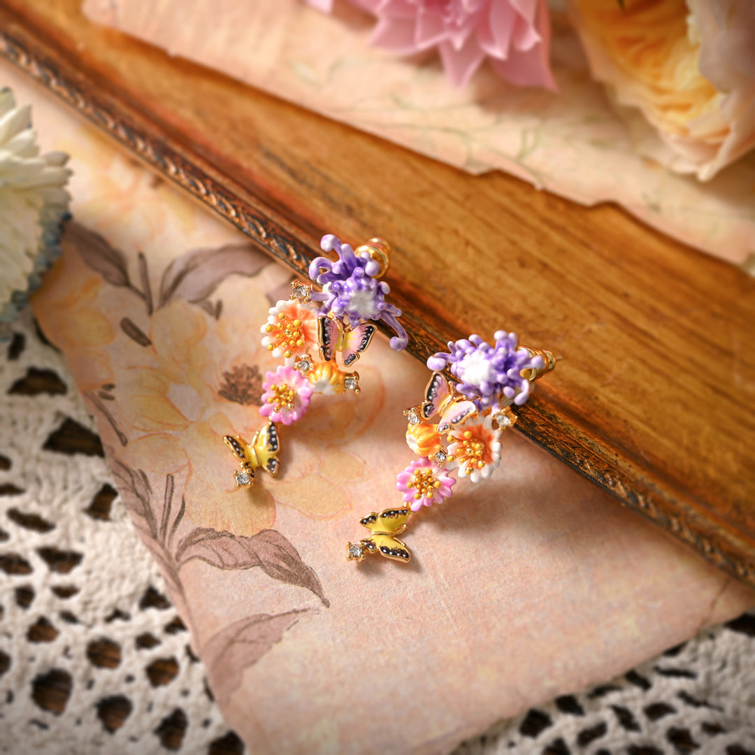 Daisy Butterfly Earrings resting on floral paper, showcasing side details of butterfly and flower 