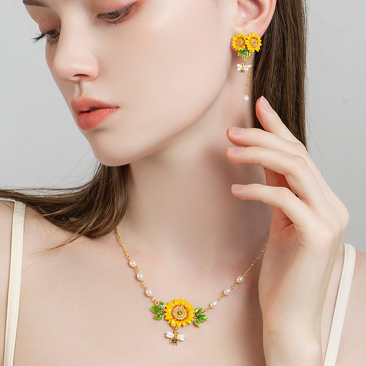 Elegant pearl-accented sunflower necklace with bee charm worn by model in profile