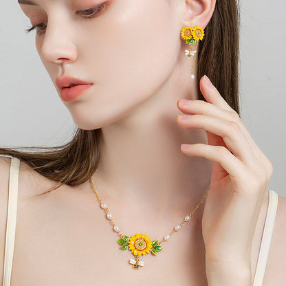 Elegant pearl-accented sunflower necklace with bee charm worn by model in profile
