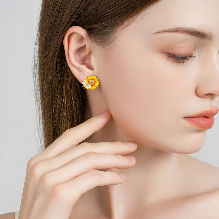 Model wearing Verdivine sunflower stud earrings with golden center and bee detail, side profile view