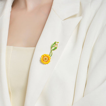 Woman wearing sunflower brooch on the lapel of a white blazer, showcasing elegant floral accessory styling