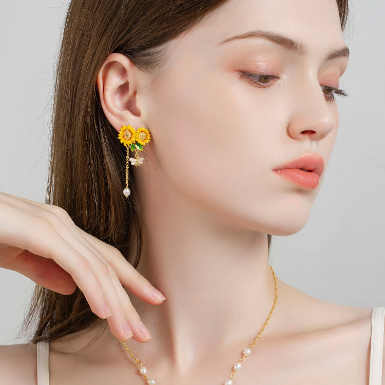 Model showcasing Verdivine sunflower earrings and matching necklace with bee and pearl details