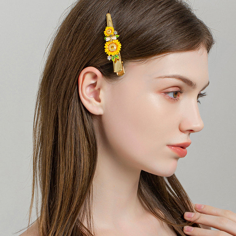 Woman with straight brown hair wearing sunflower hairpin adorned with bee and flower details