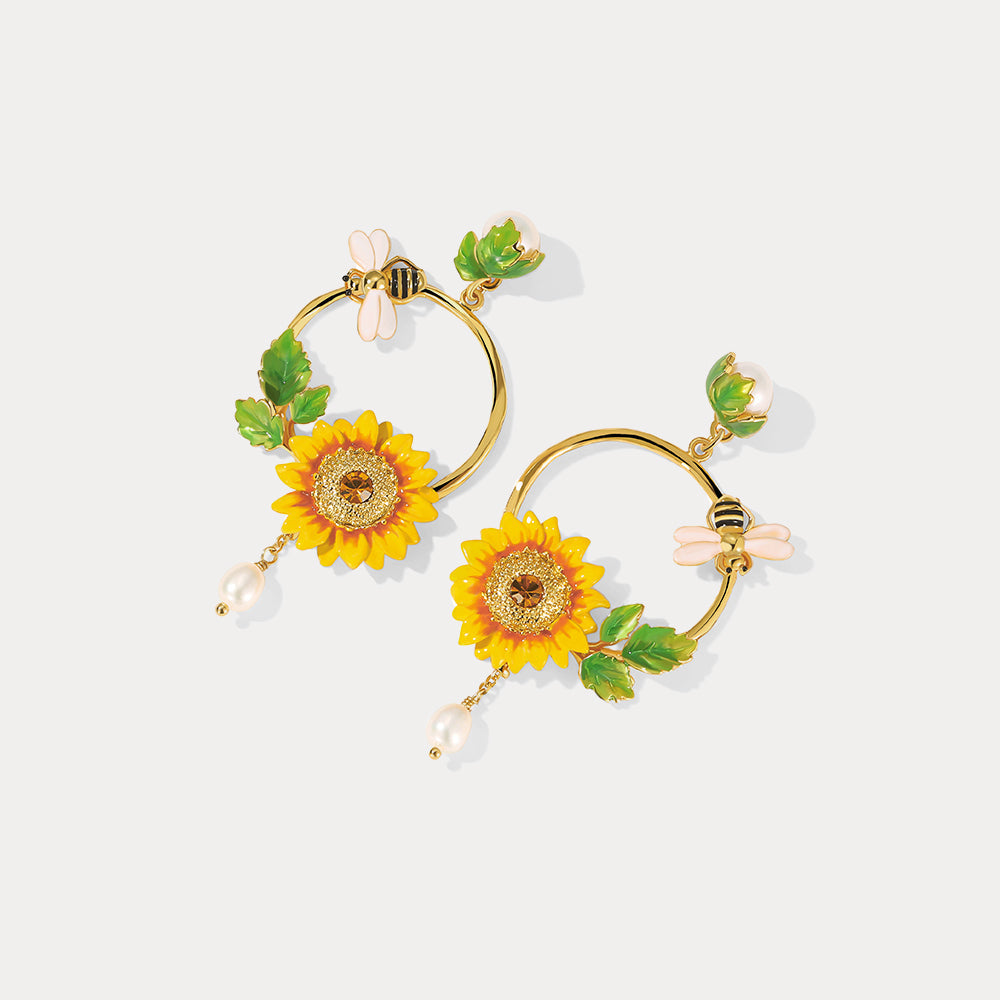 Angled view of Sunflower Hoop Earrings highlighting enamel petals and dangling pearls
