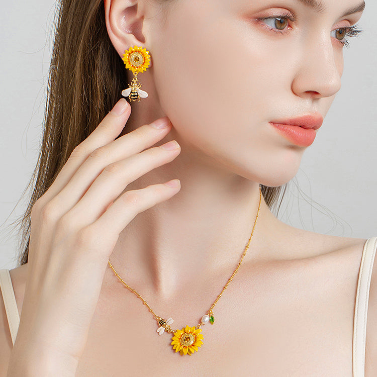 Model wearing sunflower pendant necklace featuring pearl accents and a bee charm