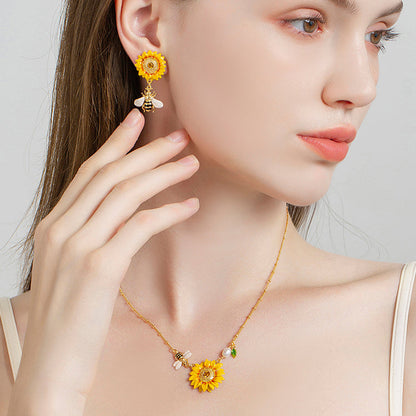 Model wearing sunflower pendant necklace featuring pearl accents and a bee charm