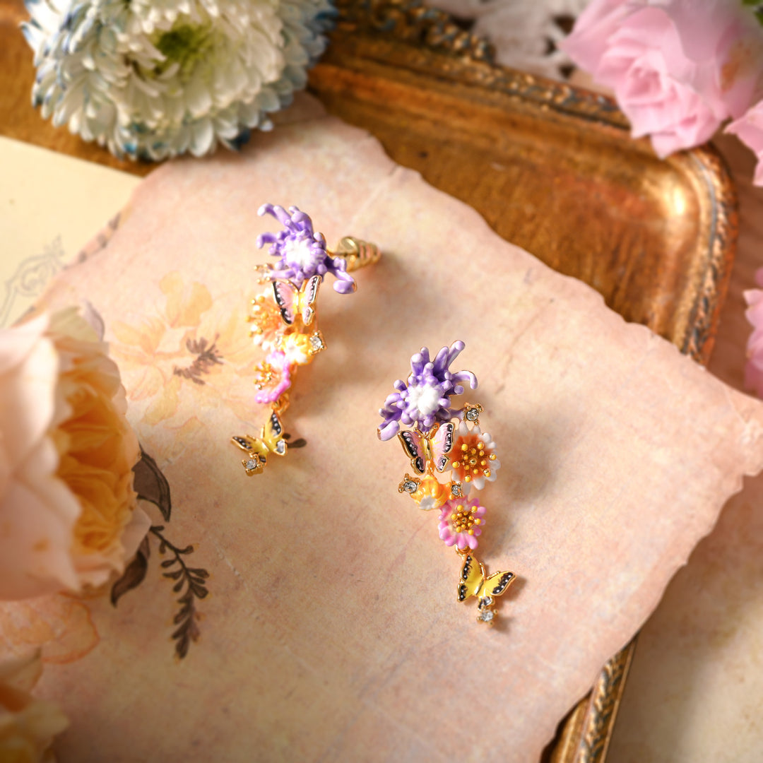 Top-down view of Daisy Butterfly Earrings on vintage floral paper with pink and cream roses