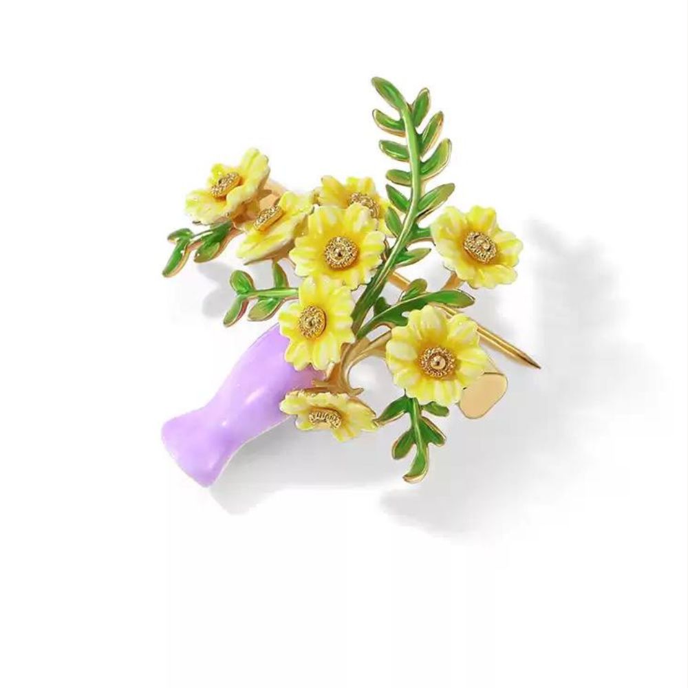 Decorative brooch featuring yellow sunflower bouquet in a purple vase with green leaves on a white background